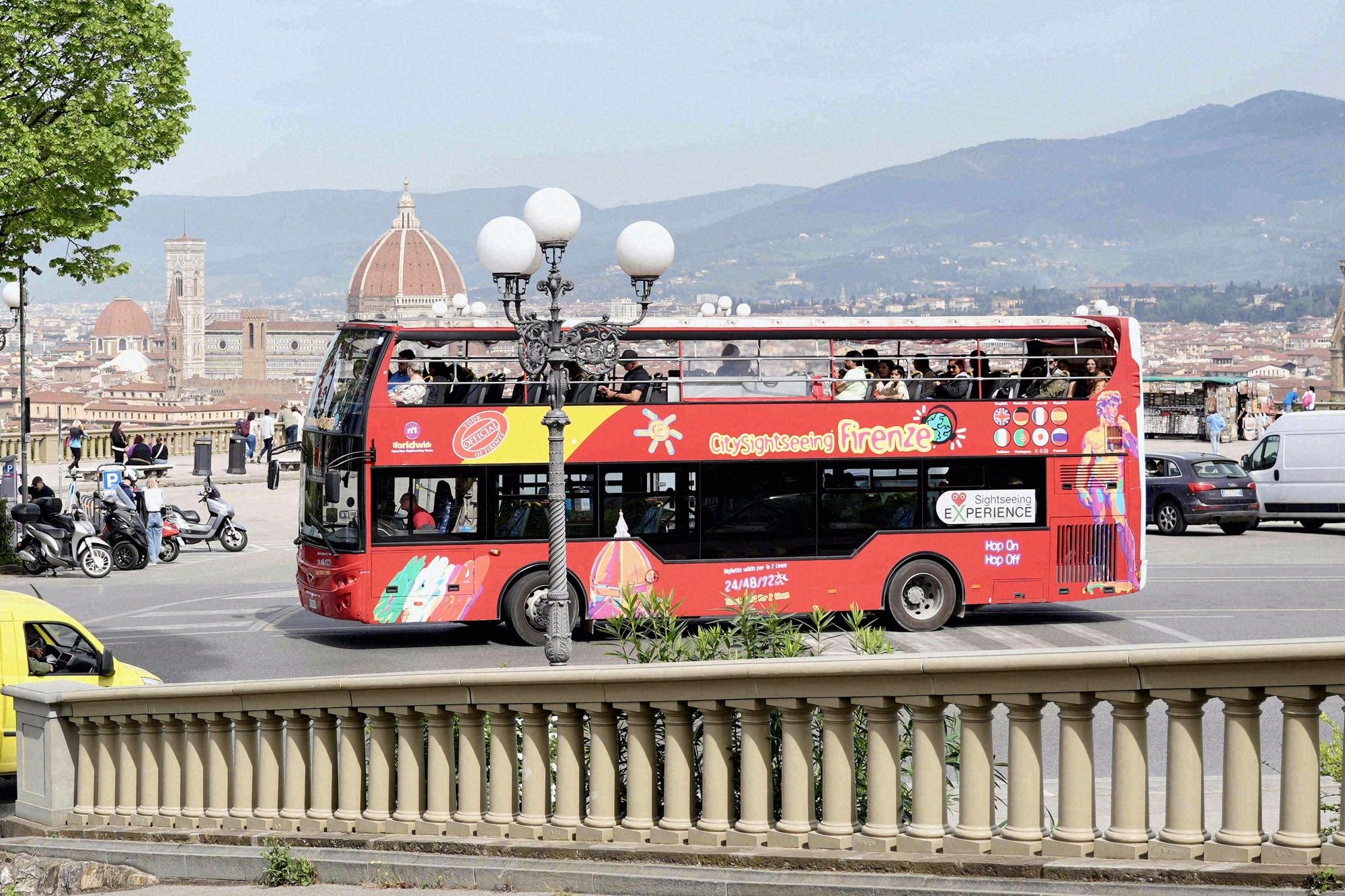Roter Hop-On-Hop-Off-Doppeldeckerbus City Sightseeing Firenze auf dem Piazzale Michelangelo mit der Brunelleschi-Kuppel im Hintergrund.