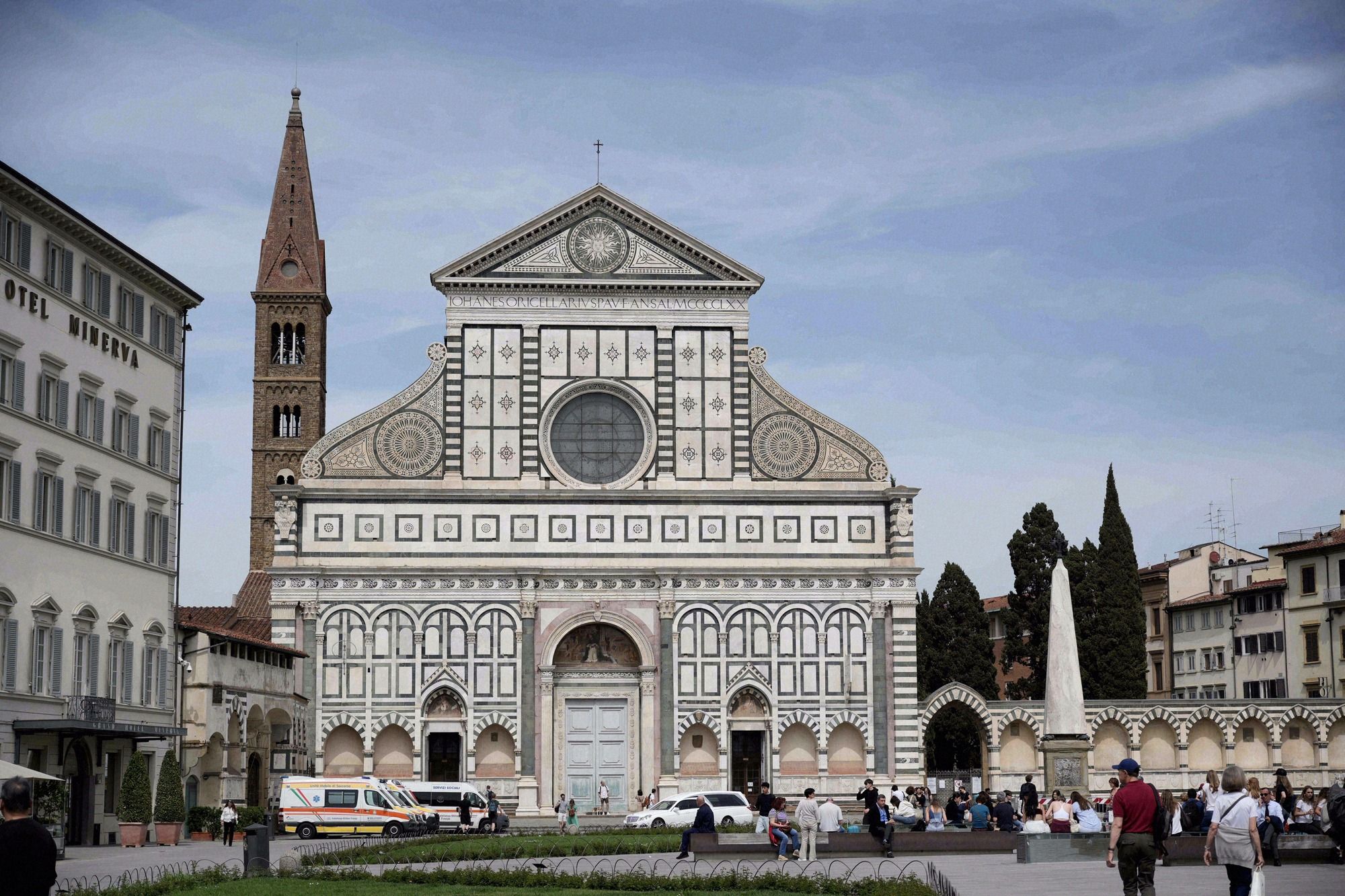 Die Fassade von Santa Maria Novella mit ihrer charakteristischen weiss-gruenen Marmorverkleidung, der Rosette und dem Glockenturm im Hintergrund.